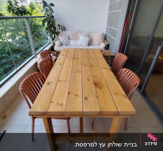 שולחן עץ וכיסאות במרפסת